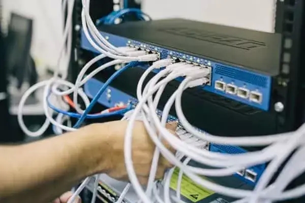 Technician Connecting Patch Leads to a Network Switch